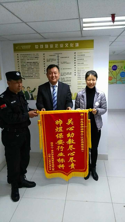 锦旗赠送现场:世茂香槟湖幼儿园负责人(右)江苏帅煜保安公司总经理